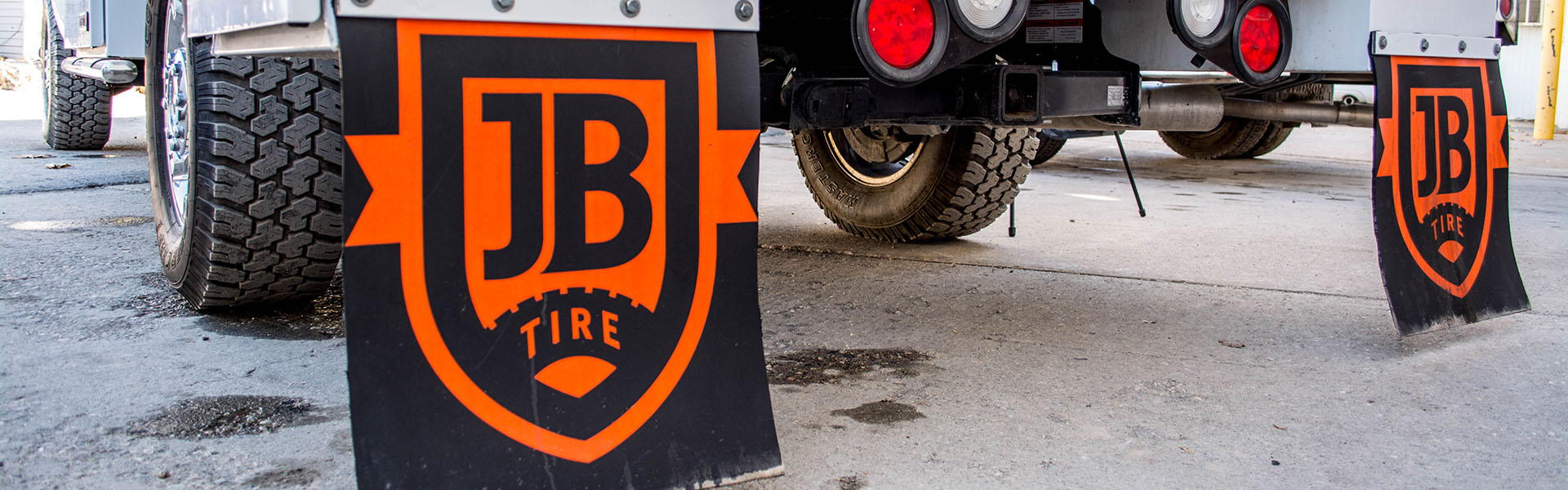 JB Tire logo mud flaps on a service truck